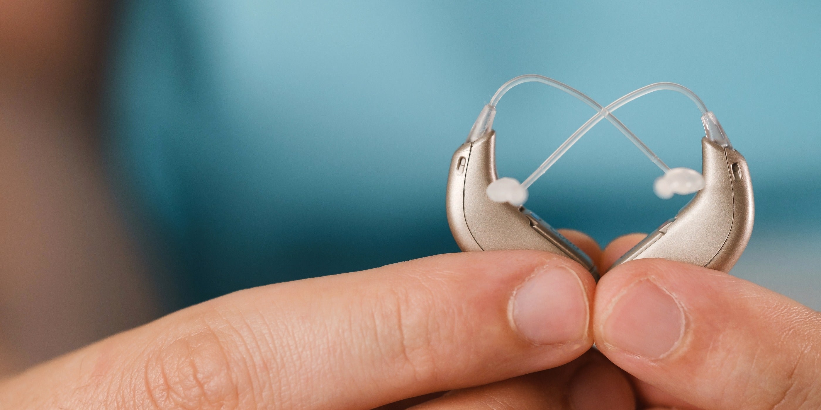 Unknown person holding pair of hearing aids